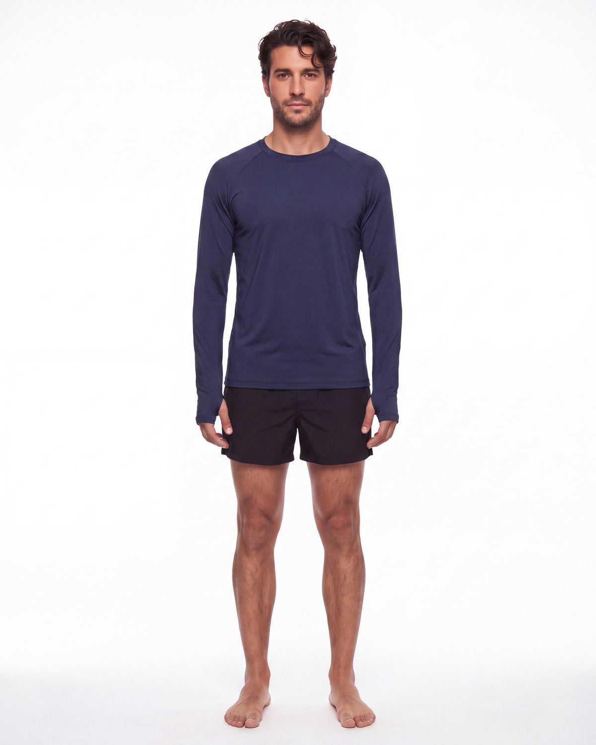 Hombre con rashguard FIJI azul marino y pantaloneta de baño, de pie de frente