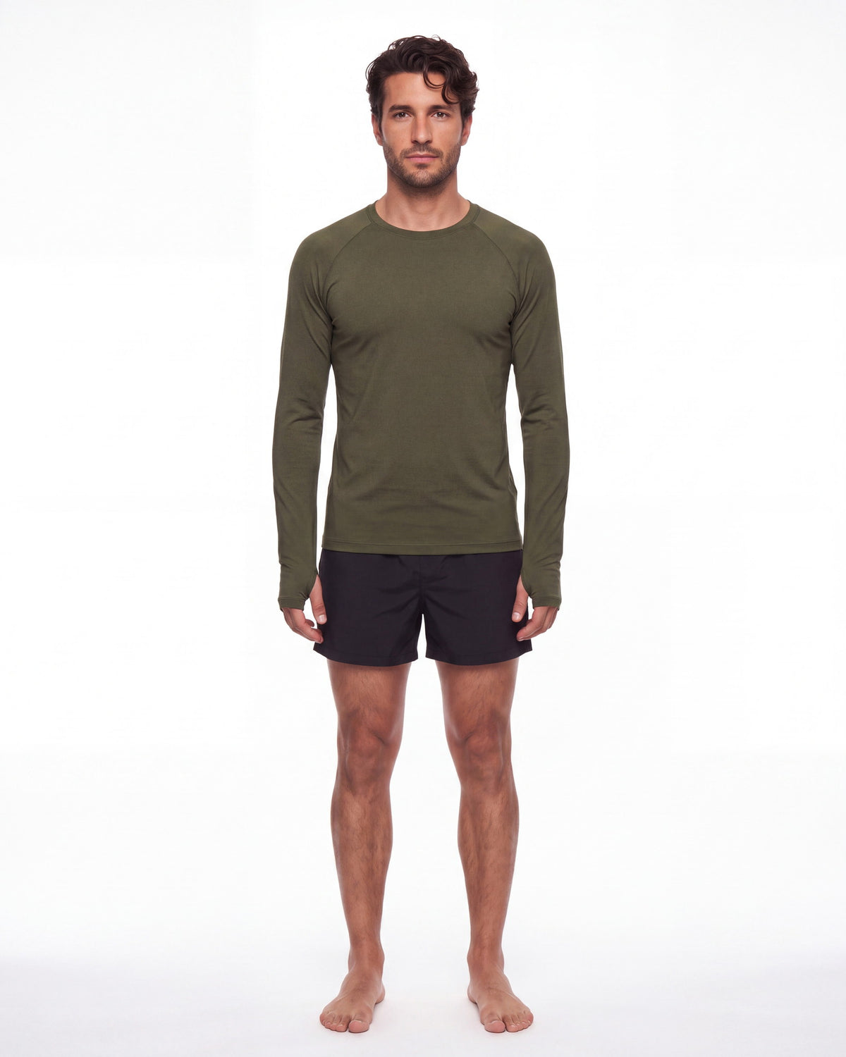Hombre con rashguard FIJI verde oliva y pantaloneta de baño, de pie de frente