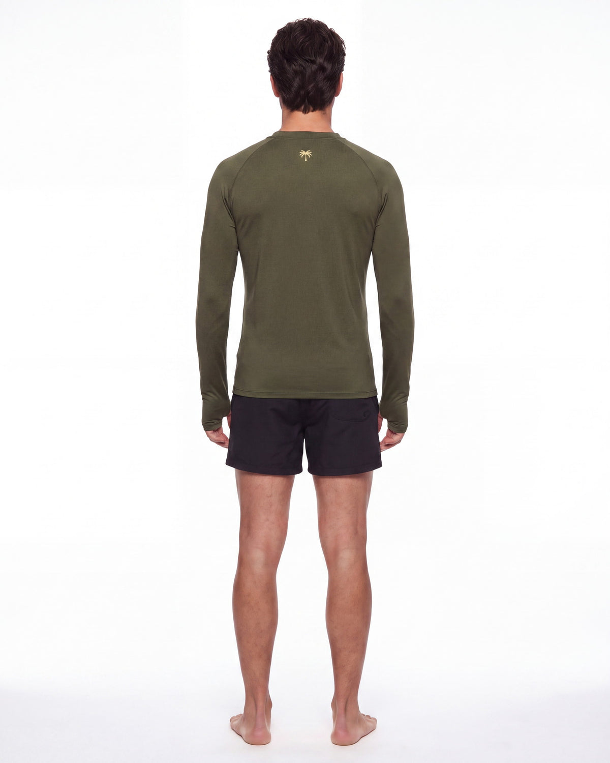 Hombre de espaldas con rashguard FIJI verde oliva; la palmera dorada queda centrada