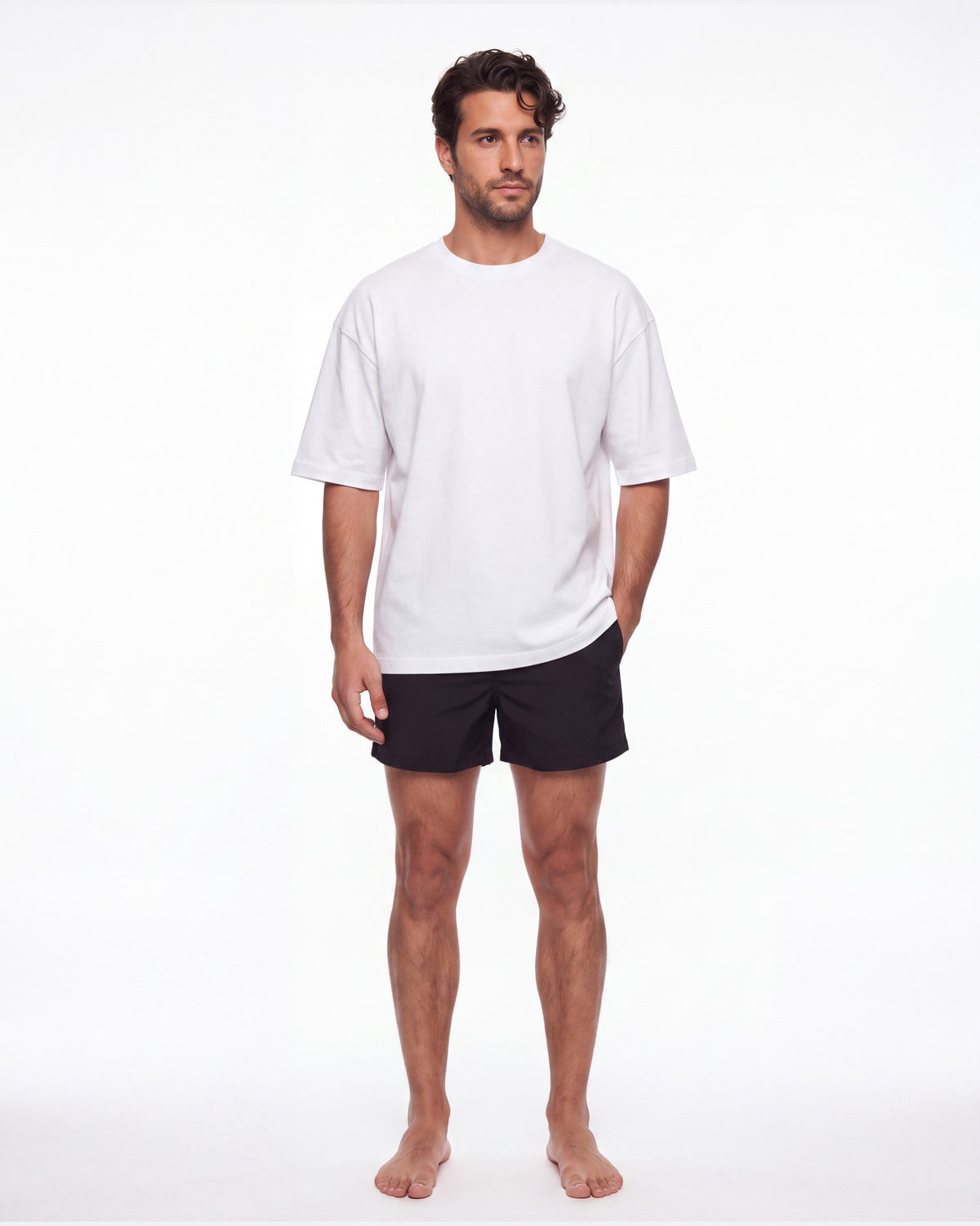 Hombre con camiseta KAI blanco y pantaloneta de baño, de pie de frente