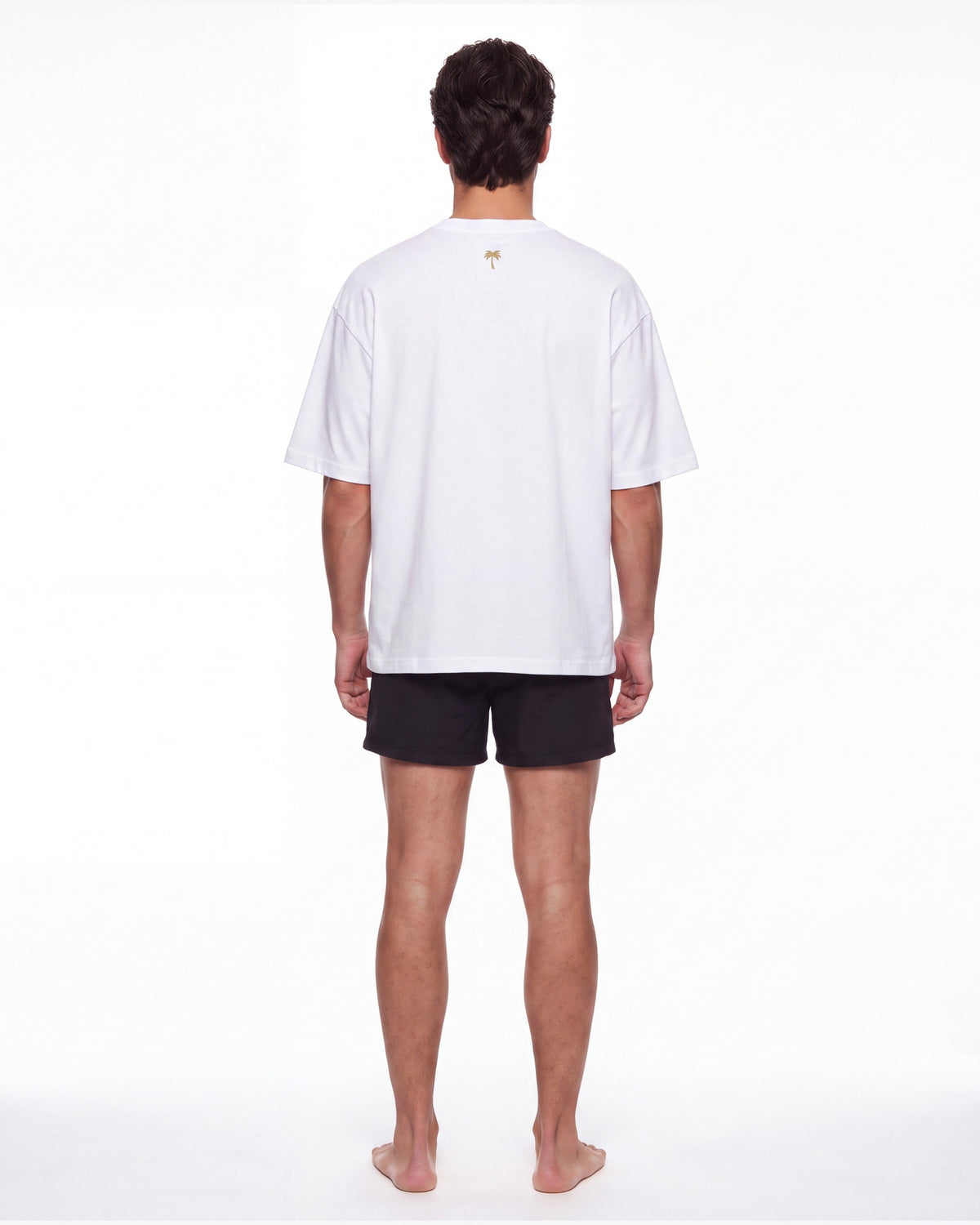 Hombre de espaldas con camiseta KAI blanco; la palmera dorada queda centrada