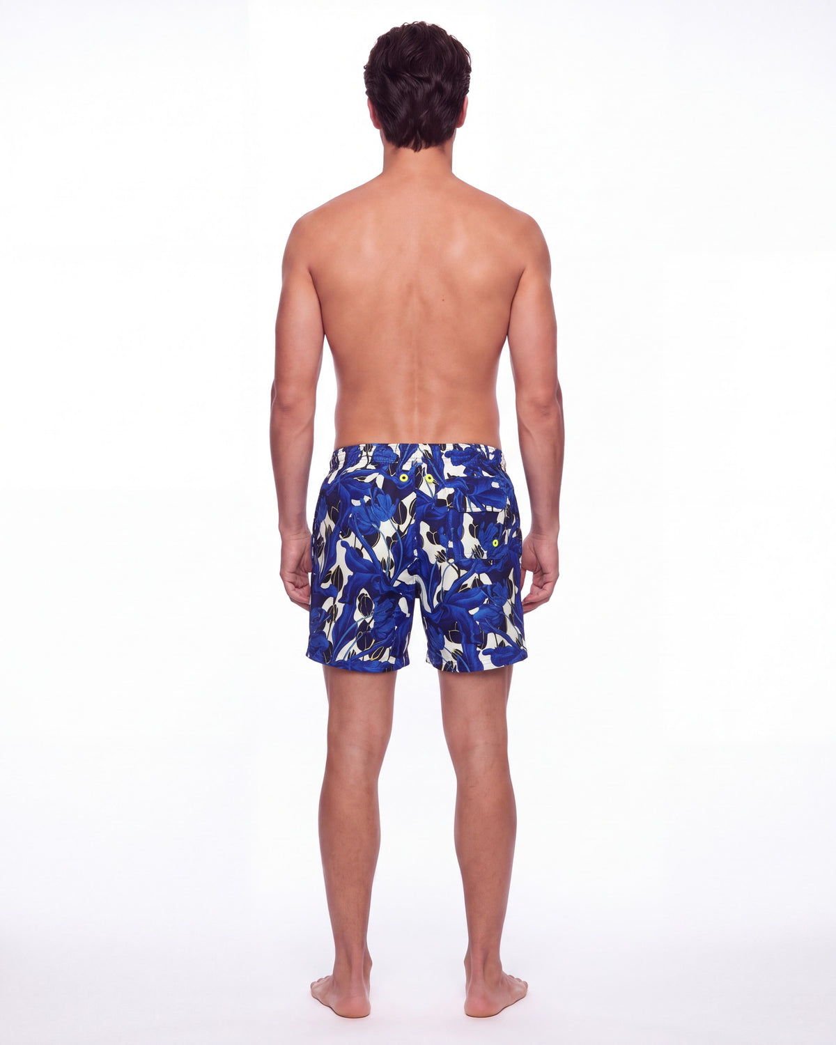 Hombre con pantaloneta de baño BORA BORA blanca con estampado tropical azul, de espaldas