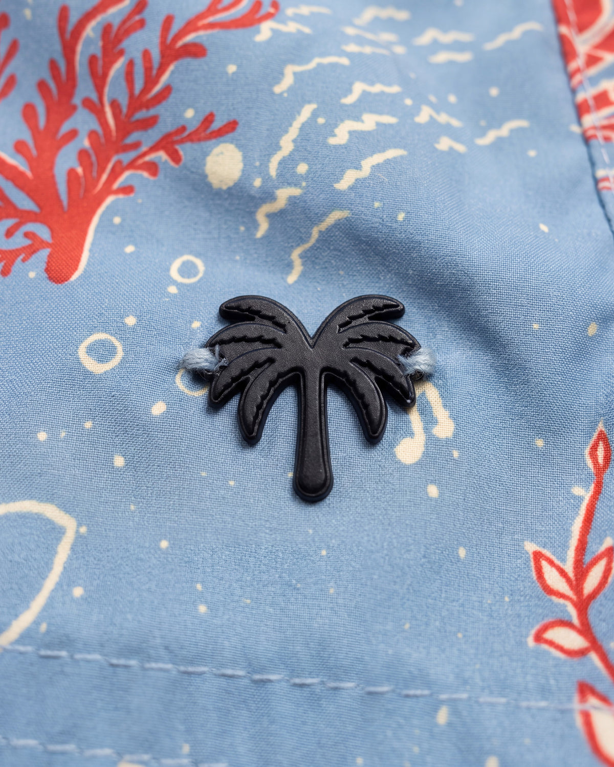 Aplique metálico de palmera en la pantaloneta de baño CRETA