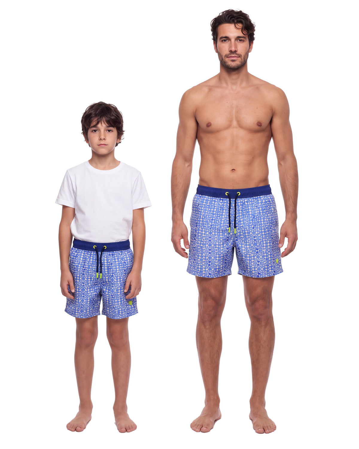 Niño y hombre con la misma pantaloneta LOS ROQUES, de frente sobre fondo blanco