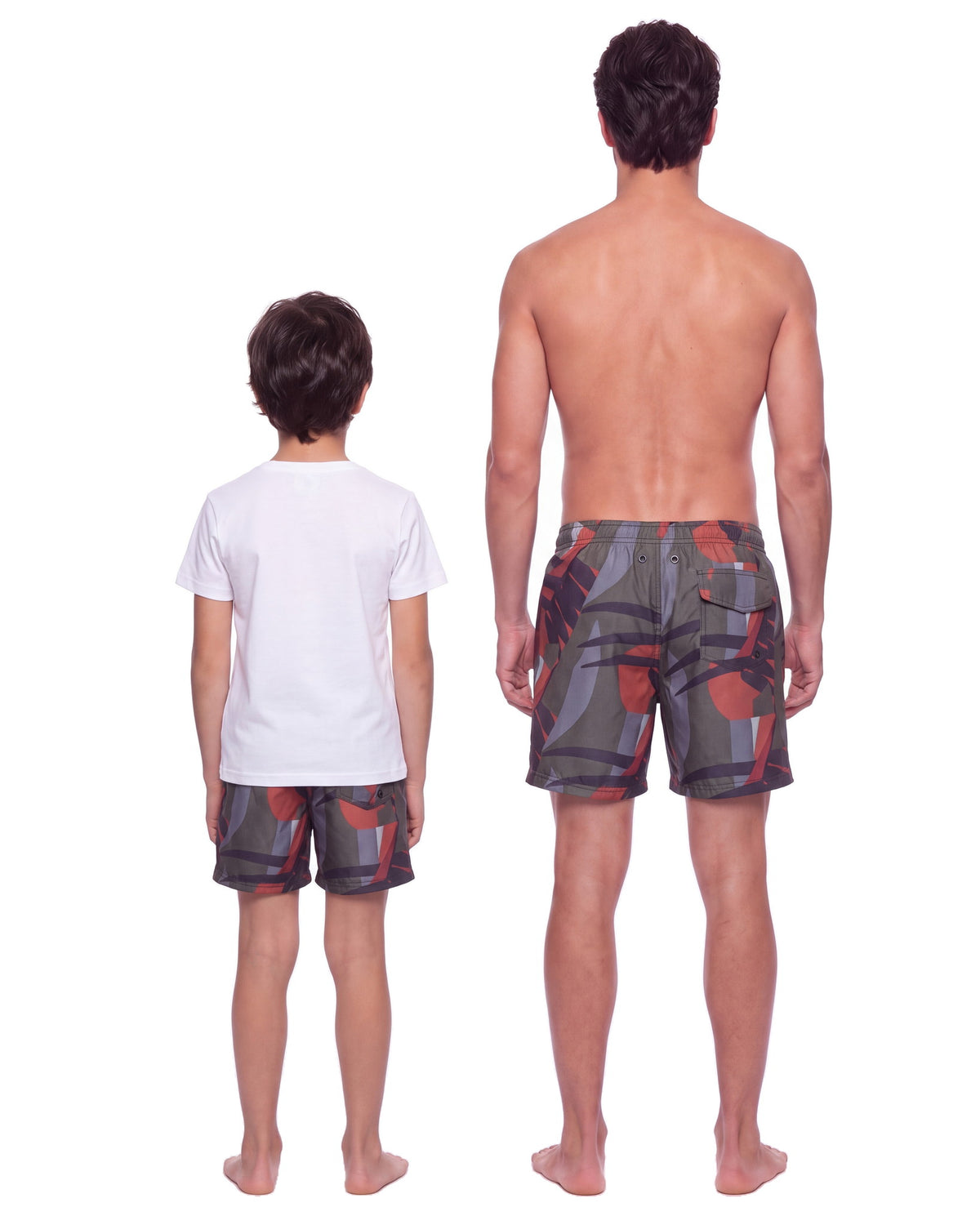 Niño y hombre con la misma pantaloneta OIA, de espaldas sobre fondo blanco