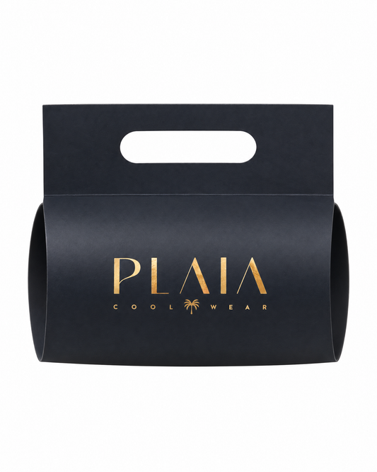 Empaque de regalo PLAIA: faja de cartón negro con logo dorado y asa troquelada