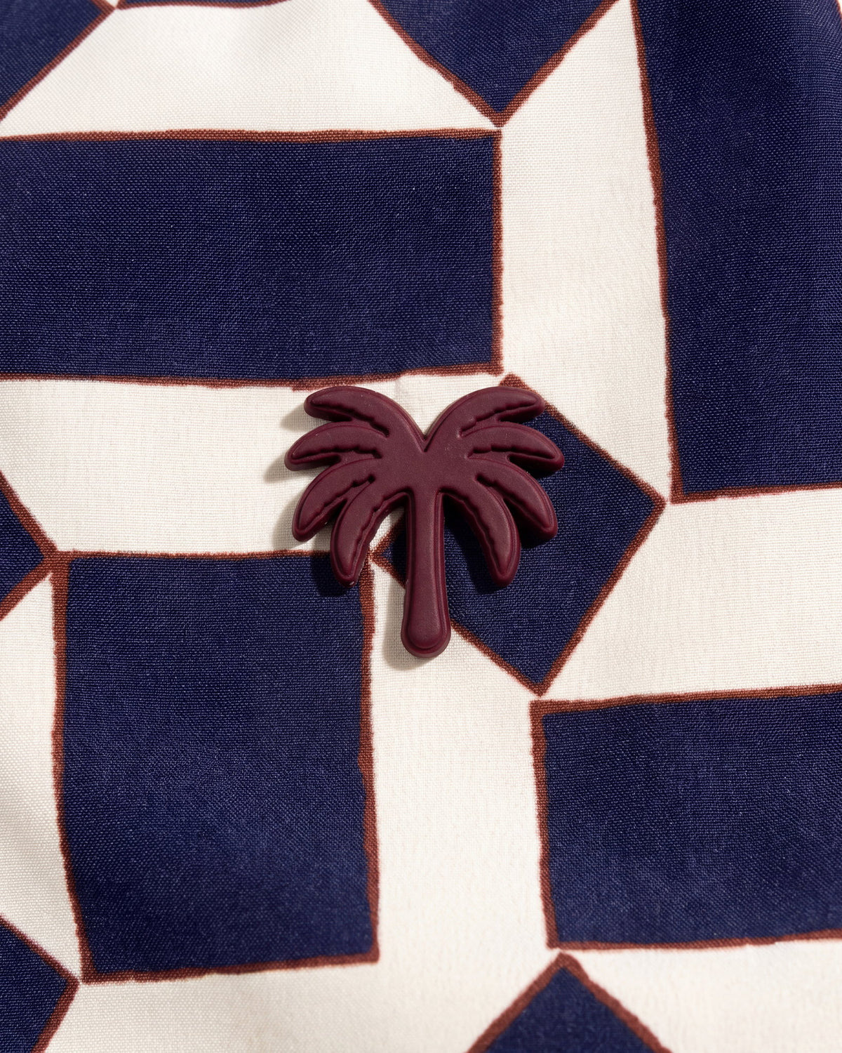 Aplique metálico de palmera en la pantaloneta de baño MILOS