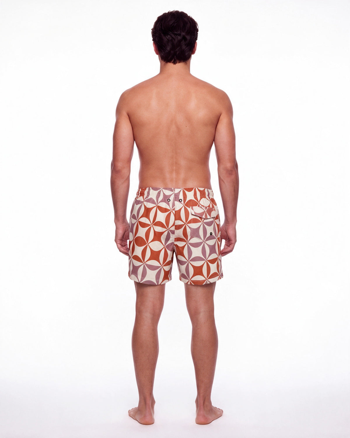 Hombre con pantaloneta de baño NISSI blanca con rosetones geométricos rojos, de espaldas
