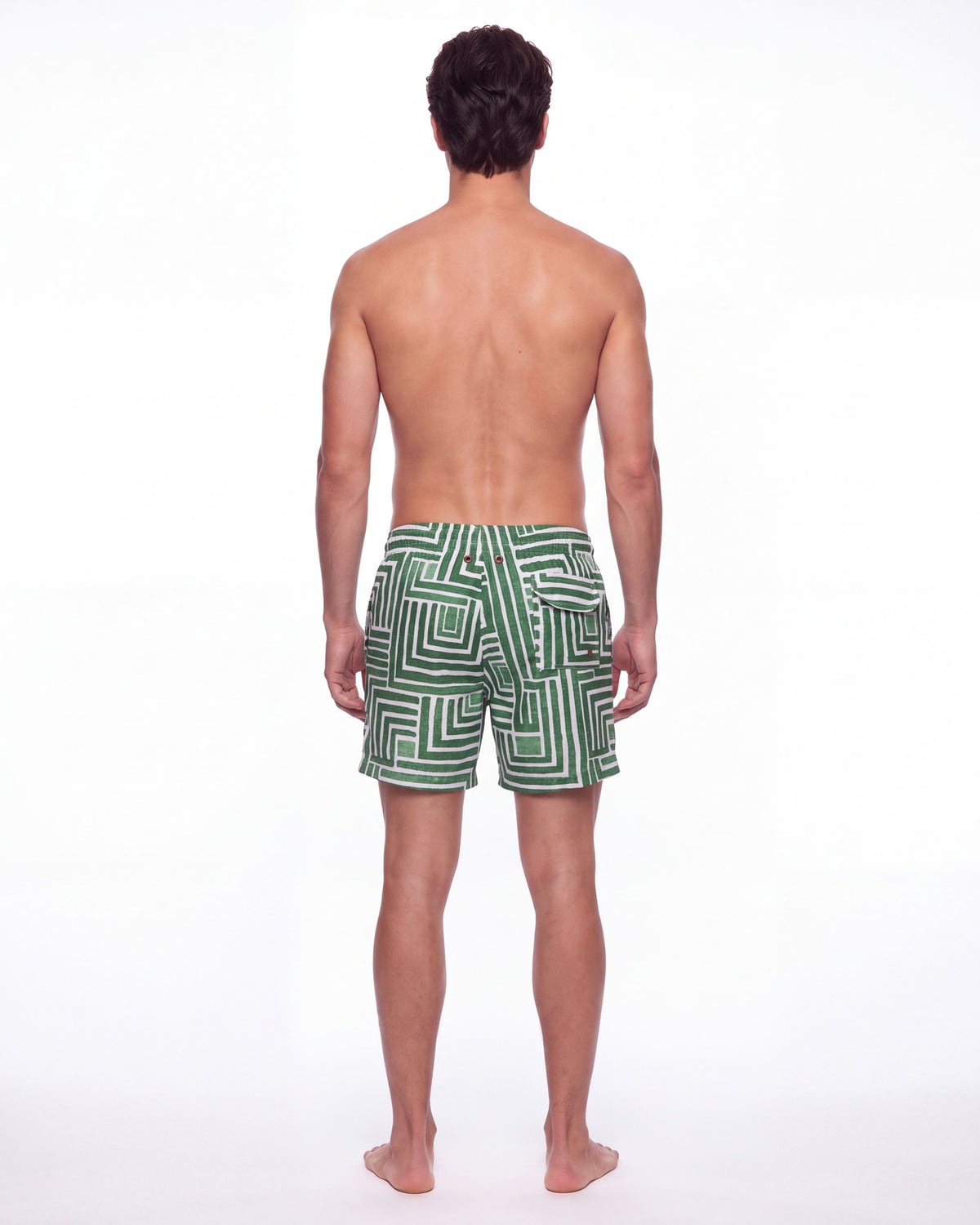 Hombre con pantaloneta de baño TULUM verde y blanca con laberinto pintado a mano, de espaldas